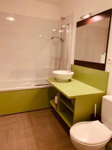 La salle de bains est pourvue d'un lavabo, de toilettes et d'une douche. dans l'établissement Terres de France - Résidence Côté Provence, à Gréoux-les-Bains