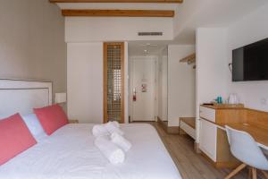 Schlafzimmer mit einem weißen Bett und einem TV in der Unterkunft Rosal by Seaward Suites Only Adults in Villajoyosa