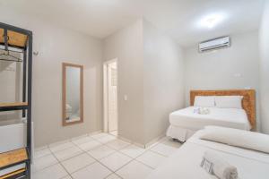 1 Schlafzimmer mit 2 Betten und einem Spiegel in der Unterkunft Mansomar in Jericoacoara