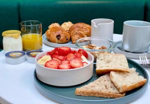 a breakfast table with a plate of fruit and bread at Le Basile H&ocirc;tel in Paris