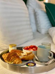 a tray of breakfast food on a bed at Le Basile H&ocirc;tel in Paris