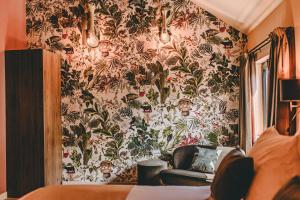 バールロにあるCentraal Baarloの壁に花の壁紙を用いた客室で、ソファが備わります。