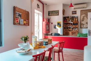 a kitchen with a table with chairs and a red wall at Ostello Bello Milano Duomo in Milan