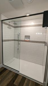 a shower with a glass enclosure in a bathroom at Cape Breton Flats in Inverness +6 photos