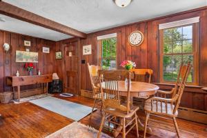 a dining room with a table and chairs and a clock at 39 Jefferson Shores Bourne - Vacation Bliss on Buttermilk Bay in Buzzards Bay