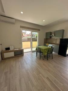 una sala da pranzo con tavolo verde e una cucina di la casetta di Max a Roma