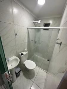 a bathroom with a shower and a toilet and a sink at Hotel Trevo Caruaru in Caruaru