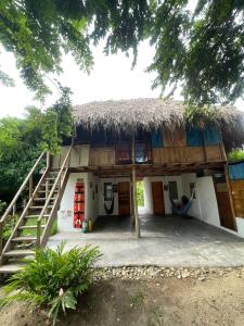 a house with a thatched roof and a staircase at Ipqua Hostel in Palomino