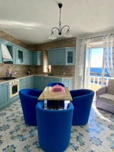 una cucina con armadi blu, tavolo e sedie di La casa Azzurra a Ischia