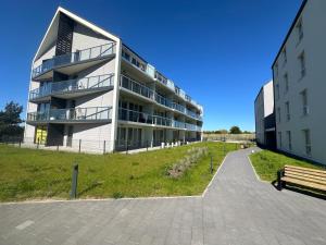 an apartment building with a bench in front of it at Osada Cetniewo by Q4Apartments in Władysławowo