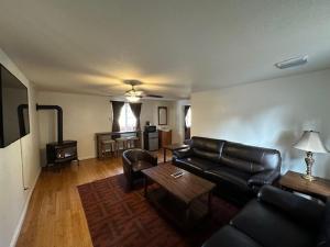 un soggiorno con divano in pelle nera e tavolo di Shasta Inn a Mount Shasta