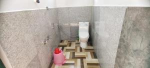a bathroom with a toilet in the corner of a wall at Johns Villa in Sultan Bathery