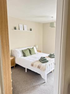 a bedroom with a white bed with towels on it at Cosy Cottage in Mersea - Walking distance to beach and town in West Mersea