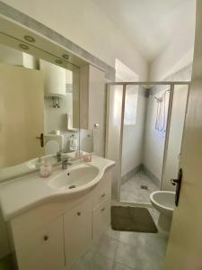 bagno bianco con lavandino e servizi igienici di La casa Azzurra a Ischia