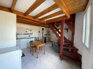 a kitchen and dining room with a wooden ceiling at Petite maison avec terrasse in Sainte-Colombe-de-Peyre