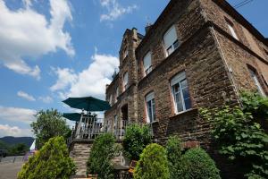a brick building with a balcony and an umbrella at Hotel Alte Bürgermeisterei in Ediger-Eller +37 photos
