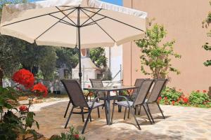 een tafel en stoelen met een parasol op een patio bij Marinos' Place in Skala Kallirakhis