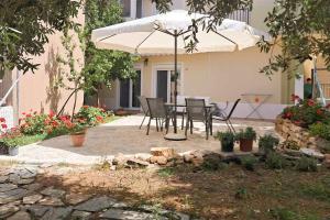 a table and chairs under an umbrella in a yard at Moloha in Skala Kallirakhis +26 photos