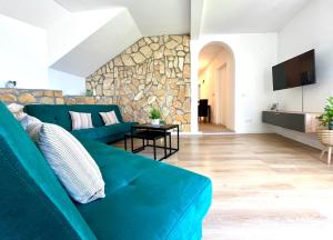 ein Wohnzimmer mit einem blauen Sofa und einer Steinmauer in der Unterkunft Villa Veronika in Lovran