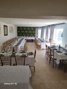 a large dining room with tables and chairs at Imany Guest House in Bloubergstrand