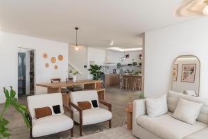 a living room with two chairs and a table at Islander - Funchal Seaside Villas in Funchal