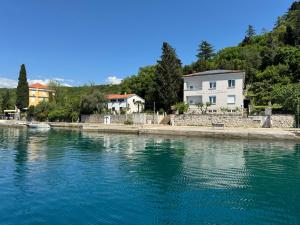 a house on the shore of a body of water at Villa Lovorka by VILLA EVA in Omišalj