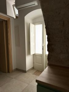 ein leeres Zimmer mit einer Tür und einem Fenster in der Unterkunft Al Murigini - Casa Vacanze in Ceglie Messapica