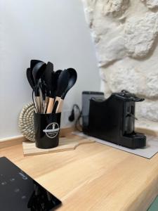 eine Tasse mit Küchenutensilien auf einer Theke in der Unterkunft Al Murigini - Casa Vacanze in Ceglie Messapica