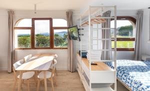 ein Schlafzimmer mit einem Etagenbett, einem Tisch und einem Schreibtisch in der Unterkunft LUR Apartments Getaria in Getaria