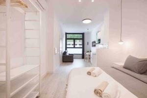 a white bedroom with a bed and a living room at LUR Apartments Getaria in Getaria