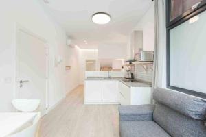 duża biała kuchnia z kanapą i łazienką w obiekcie LUR Apartments Getaria w mieście Getaria