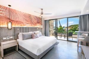 セントジョンズにあるRoyalton CHIC Antigua, An Autograph Collection All-Inclusive Resort - Adults Onlyのベッドルーム(ベッド1台付)、バルコニーが備わります。