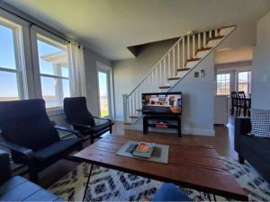 a living room with a couch and a stair case at The Cabot Suite in Chéticamp
