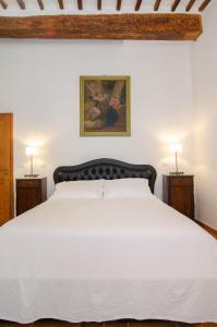 a bedroom with a large white bed with two lamps at Holiday Home Adelaide in Pienza