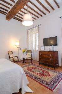 a bedroom with a bed and a tv and a table at Holiday Home Adelaide in Pienza