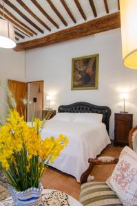 a bedroom with a bed and a vase of yellow flowers at Holiday Home Adelaide in Pienza