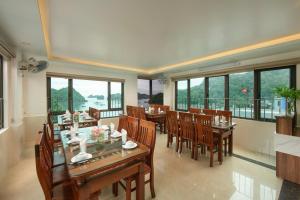 DUNG LAI HOTEL 173 في كات با: غرفة طعام مع طاولات وكراسي ونوافذ