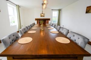 a long wooden table in a room with chairs at The Farmhouse Private HOT TUB & SAUNA & TV-CINEMA Room Very Special Home Near Cannock Chase in Colton