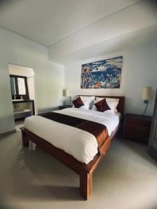 a bedroom with a large bed in a room at Pondok Dauh Ancak in Tabanan