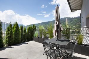 a patio with a table and an umbrella at Residence soleluna - Appartamento Orsa Minore in Roisan