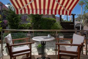 - une table et des chaises sous un parasol sur la terrasse dans l'établissement Athina résidence, à Nydri
