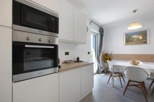 a kitchen with a microwave oven and a table at Residence soleluna - Appartamento Orsa Minore in Roisan