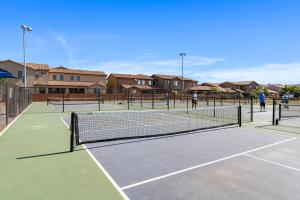 a group of people playing tennis on a tennis court at Four-Bedroom House in Santa Clara