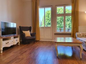 Televízia a/alebo spoločenská miestnosť v ubytovaní Apartament Śliwka na Monte