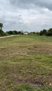 a field of grass with a house in the distance at Rumah Menara Malay Homestay in Klang