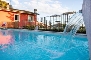 uma fonte de água numa piscina em The Sunset Hill with Private Swimming pool and A/C em Camaiore