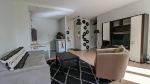 ein Wohnzimmer mit einem Sofa und einem Stuhl in der Unterkunft Appartement d'une chambre avec wifi a Palaiseau in Palaiseau