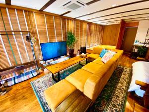 廣島的住宿－villa garden DaiDai，客厅配有沙发和桌子