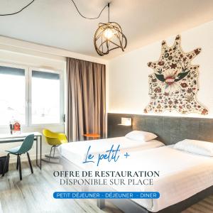 a hotel room with a bed and a desk at The Originals City, H&ocirc;tel Le Berry, Bourges in Bourges