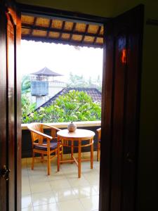 ein Raum mit einem Tisch und Stühlen und einem Fenster in der Unterkunft Kabera Bungalow 3 in Ubud